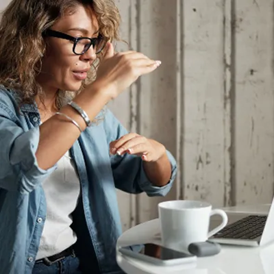 Mulher participando de uma reunião de forma online no seu notebook